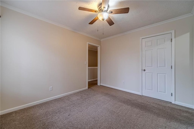 carpeted empty room featuring ornamental molding, ceiling fan, and a textured ceiling