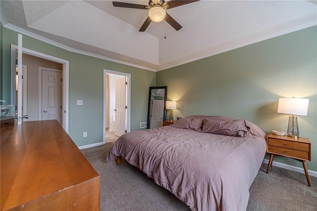 carpeted bedroom with ceiling fan, connected bathroom, ornamental molding, a textured ceiling, and a raised ceiling