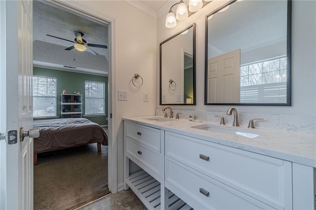 bathroom featuring ceiling fan, ornamental molding, and vanity