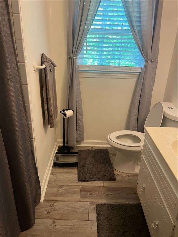 148 River N Blvd, Macon, GA 31211 - full bath featuring toilet, vanity, wood finished floors, and baseboards