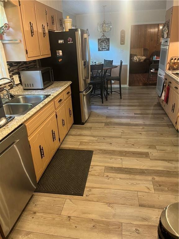 148 River N Blvd, Macon, GA 31211 - kitchen featuring light wood finished floors, a sink, decorative backsplash, light countertops, and appliances with stainless steel finishes