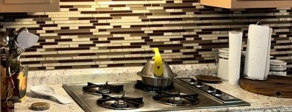 148 River N Blvd, Macon, GA 31211 - interior details featuring backsplash, light stone countertops, and stainless steel gas cooktop