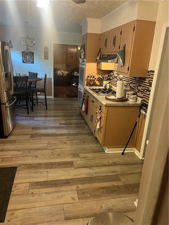 148 River N Blvd, Macon, GA 31211 - kitchen featuring ornamental molding, decorative backsplash, appliances with stainless steel finishes, light wood-style flooring, and under cabinet range hood