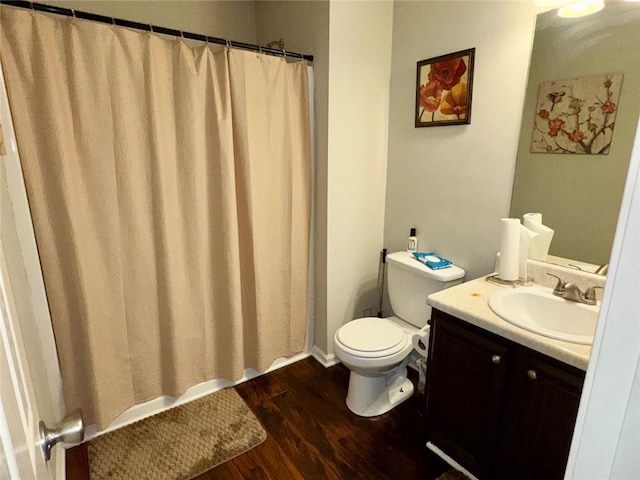 bathroom with hardwood / wood-style floors, vanity, and toilet