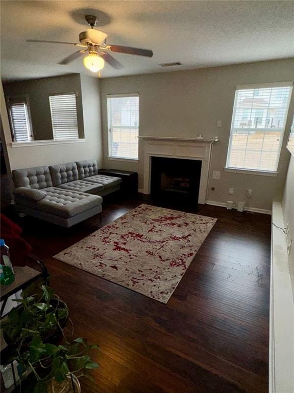 living room featuring a textured ceiling, dark hardwood / wood-style flooring, and ceiling fan