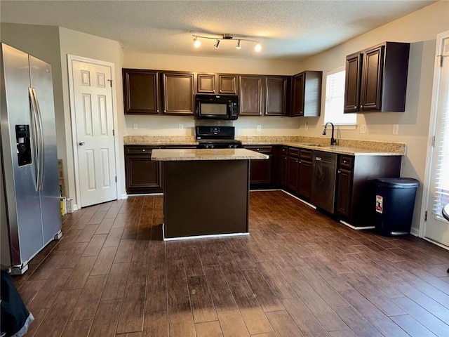 kitchen featuring black appliances, sink, dark brown cabinets, a kitchen island, and dark hardwood / wood-style flooring