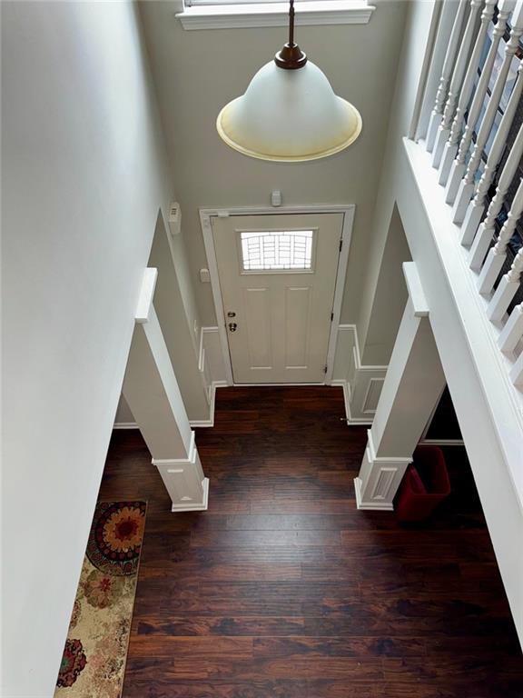 entryway featuring dark hardwood / wood-style flooring and a towering ceiling