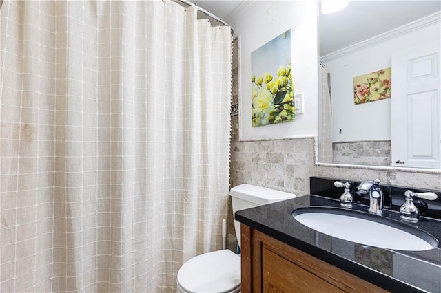 bathroom featuring a wainscoted wall, crown molding, toilet, vanity, and tile walls
