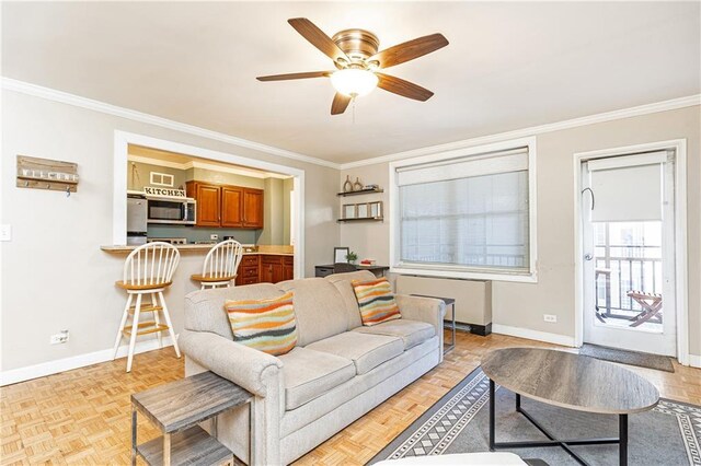 living area featuring baseboards, crown molding, and a ceiling fan