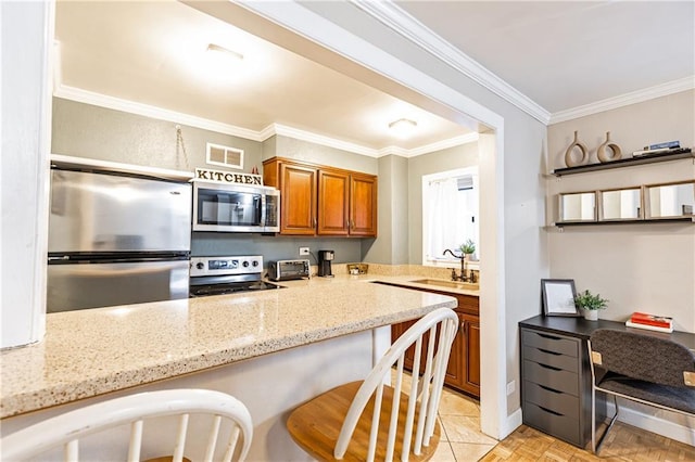 kitchen with visible vents, appliances with stainless steel finishes, crown molding, and brown cabinets