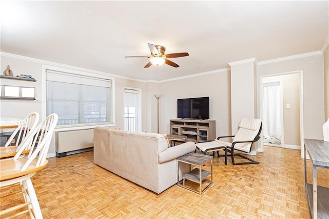 living room with baseboards, crown molding, and a ceiling fan