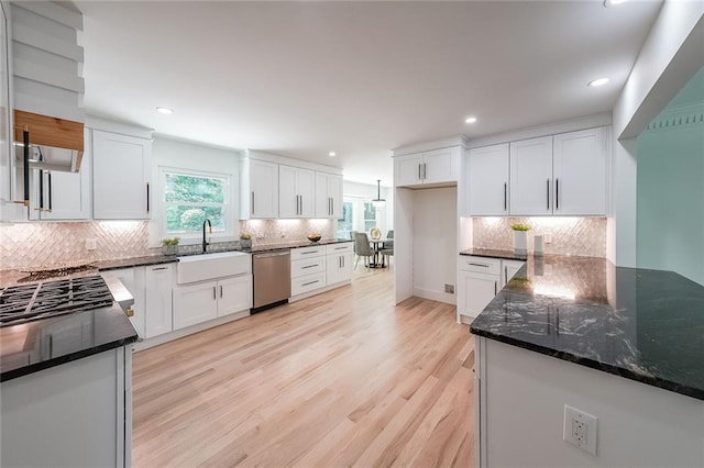 kitchen featuring light wood-type flooring, white cabinetry, and dishwasher