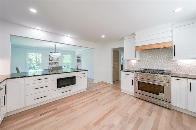 kitchen with high end range, light hardwood / wood-style flooring, black microwave, and white cabinets