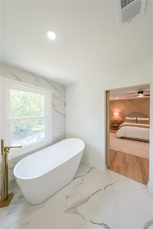 bathroom featuring a bathtub and tile walls