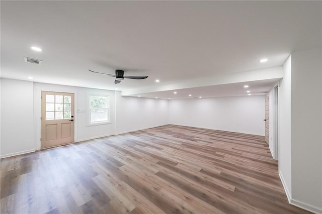 basement with ceiling fan and light hardwood / wood-style flooring