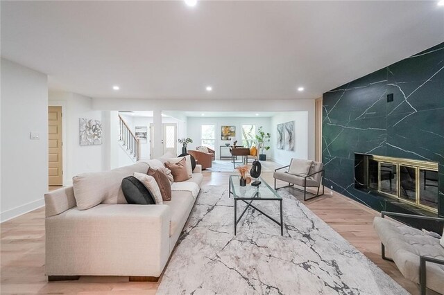 living room featuring a fireplace, light hardwood / wood-style floors, and tile walls