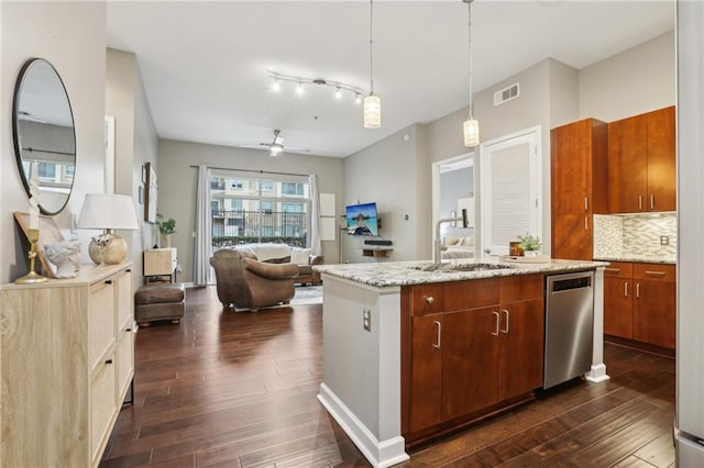 kitchen with decorative light fixtures, an island with sink, sink, backsplash, and stainless steel dishwasher