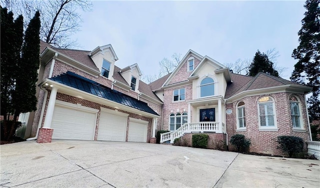 traditional home featuring a garage, brick siding, and driveway