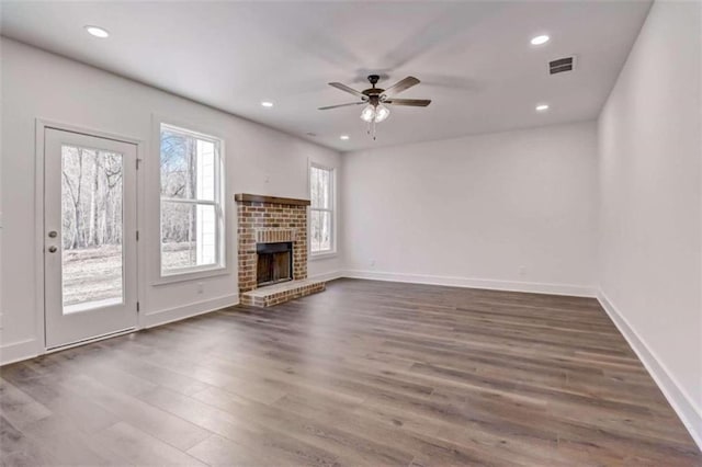 unfurnished living room with ceiling fan, a fireplace, and dark hardwood / wood-style flooring