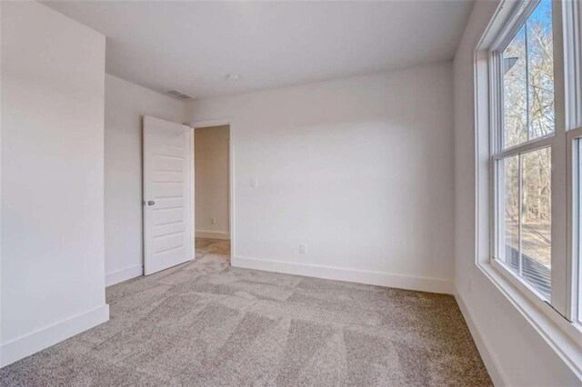 unfurnished room featuring light carpet and a healthy amount of sunlight