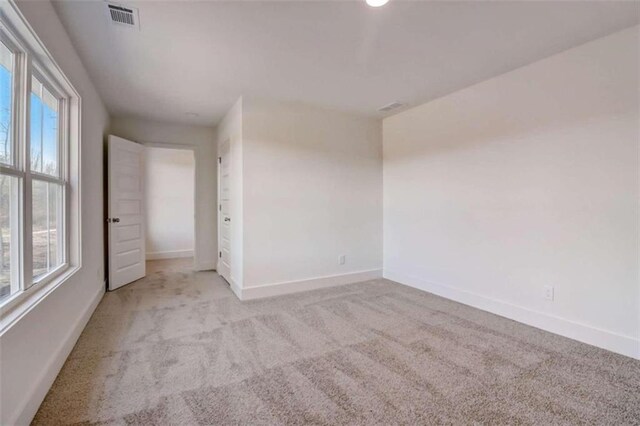 unfurnished bedroom with multiple windows and light colored carpet