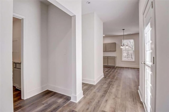 hallway featuring a notable chandelier and hardwood / wood-style floors