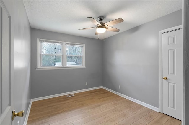 unfurnished room with ceiling fan, light hardwood / wood-style flooring, and a textured ceiling