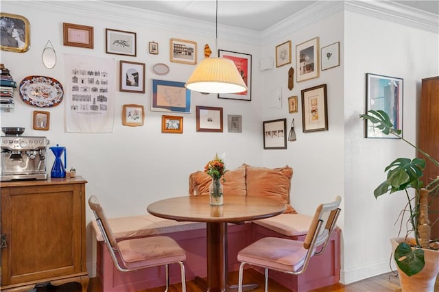 dining room featuring crown molding, breakfast area, and light wood-type flooring