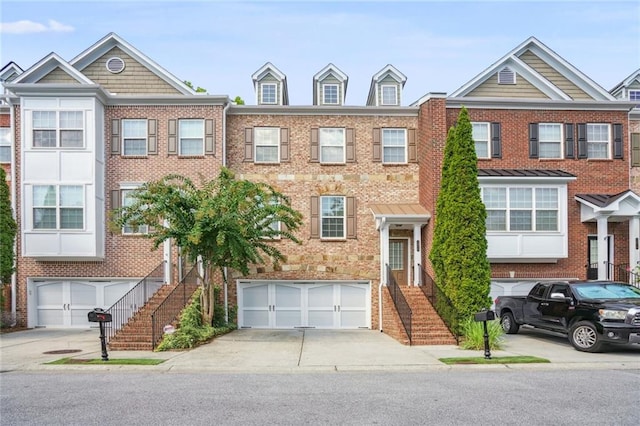 view of property featuring brick siding, concrete driveway, and a garage