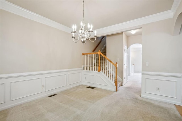 spare room with light carpet, a notable chandelier, and crown molding