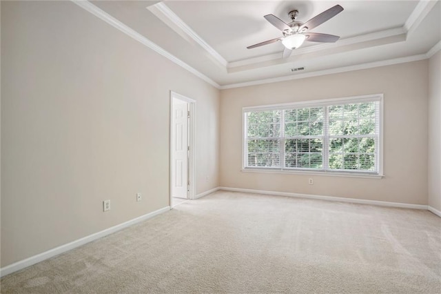 carpeted spare room featuring ceiling fan, a raised ceiling, and crown molding