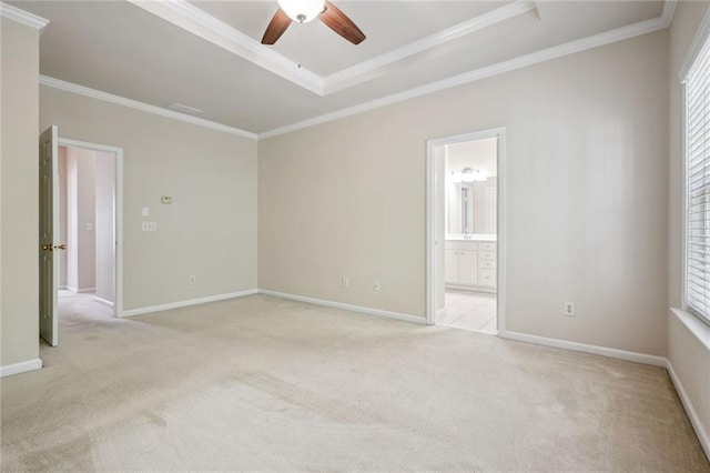 carpeted empty room with ceiling fan, a raised ceiling, and crown molding