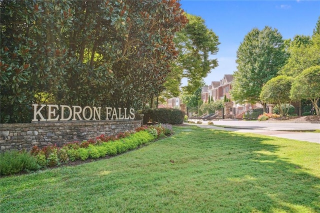 community sign featuring a residential view and a lawn