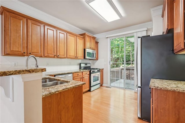 kitchen with decorative backsplash, light hardwood / wood-style floors, light stone countertops, and stainless steel appliances