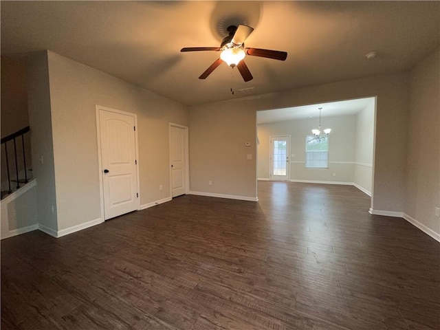 unfurnished room with dark wood finished floors, stairway, baseboards, and ceiling fan with notable chandelier