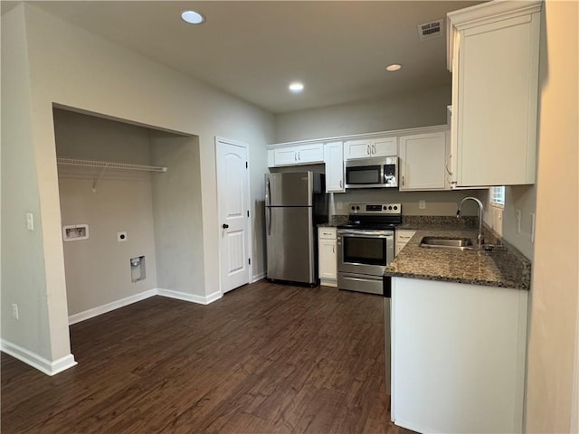 kitchen featuring visible vents, dark wood finished floors, appliances with stainless steel finishes, white cabinetry, and a sink