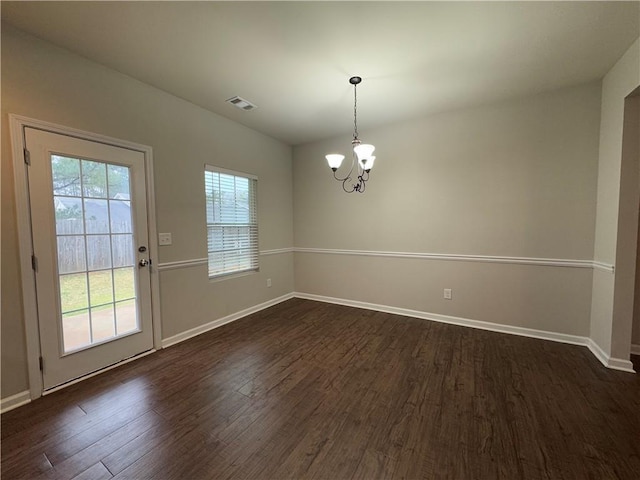 interior space featuring dark wood-type flooring, a chandelier, visible vents, and baseboards