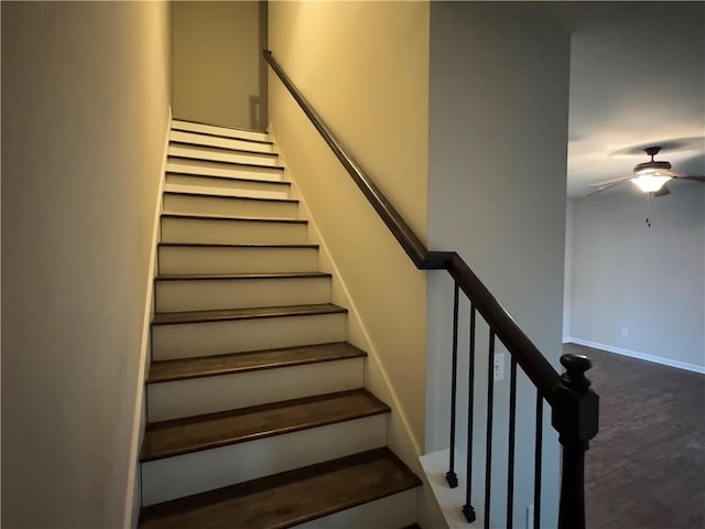 staircase with ceiling fan, baseboards, and wood finished floors