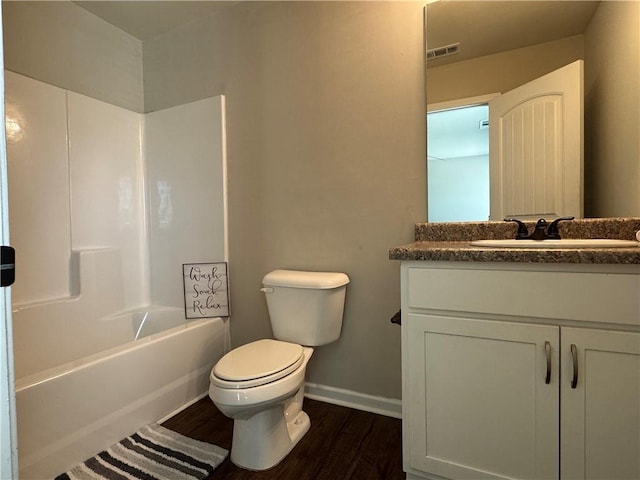 bathroom featuring shower / bathing tub combination, toilet, vanity, wood finished floors, and baseboards