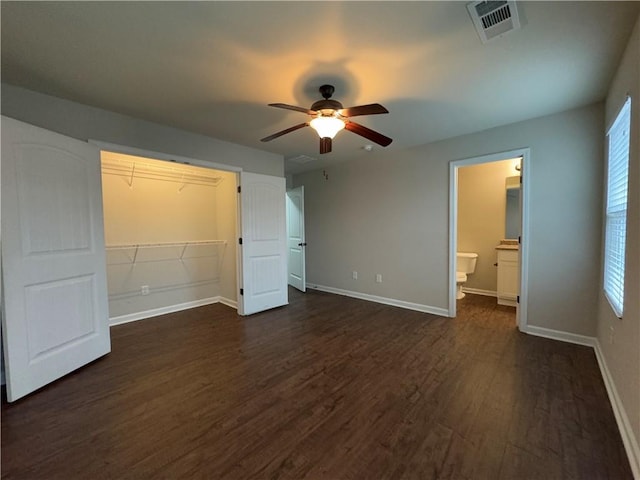 unfurnished bedroom with dark wood finished floors, a closet, visible vents, ceiling fan, and baseboards