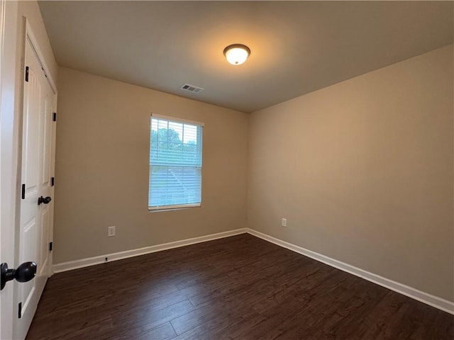 unfurnished bedroom featuring baseboards, visible vents, dark wood finished floors, and a closet