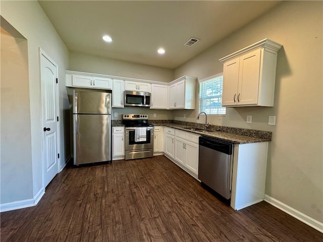 kitchen with dark wood-type flooring, visible vents, stainless steel appliances, and a sink