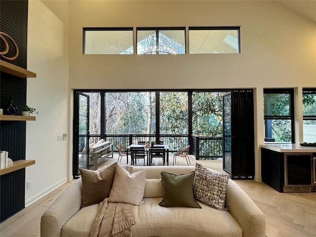 living room featuring baseboards and a towering ceiling