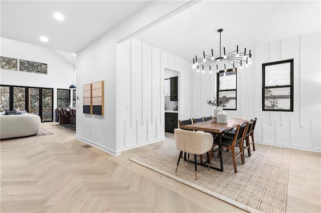 dining space featuring recessed lighting, baseboards, a high ceiling, and an inviting chandelier