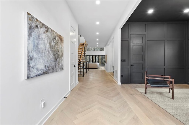 corridor featuring a decorative wall, recessed lighting, and baseboards