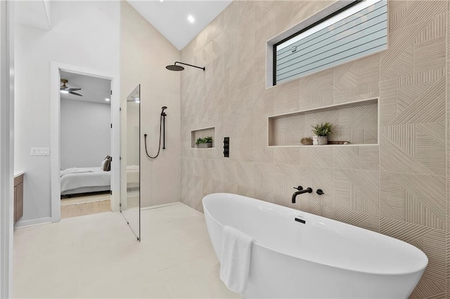 bathroom with a soaking tub, a walk in shower, tile walls, and ensuite bathroom