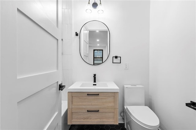 bathroom featuring vanity, tile patterned floors, toilet, and a bathing tub