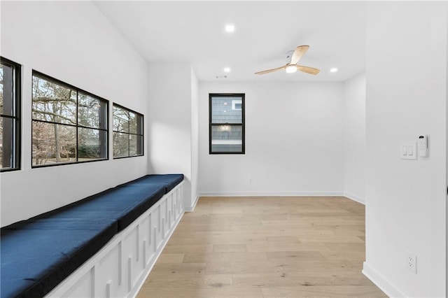 corridor with light wood-style flooring, recessed lighting, and baseboards