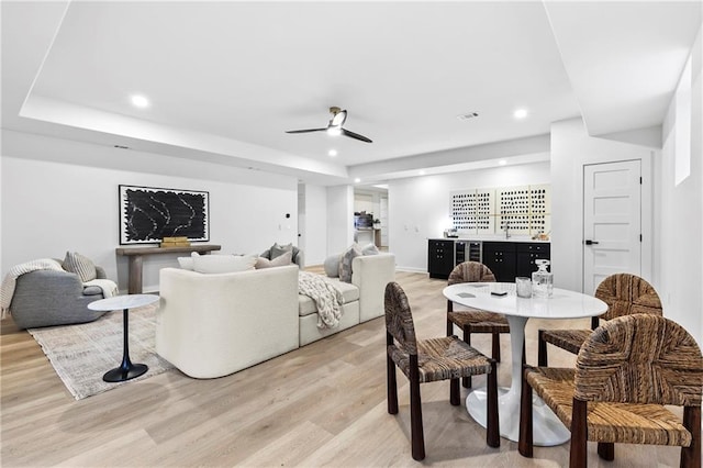 living room with light wood finished floors, visible vents, recessed lighting, a bar, and a ceiling fan