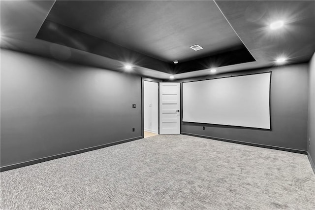 carpeted cinema room with a raised ceiling, recessed lighting, baseboards, and visible vents